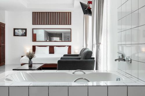 a white bathroom with a tub and a bed at S 2 Modern Boutique Hotel in Vientiane