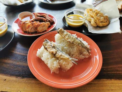 Pakarang Resort في ساتون: طبقين من الطعام مع سمك ورز على طاولة