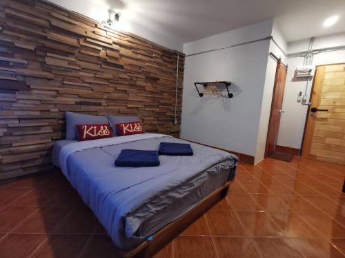 沙敦的住宿－Pakarang Resort，一间卧室设有一张带木墙的大床