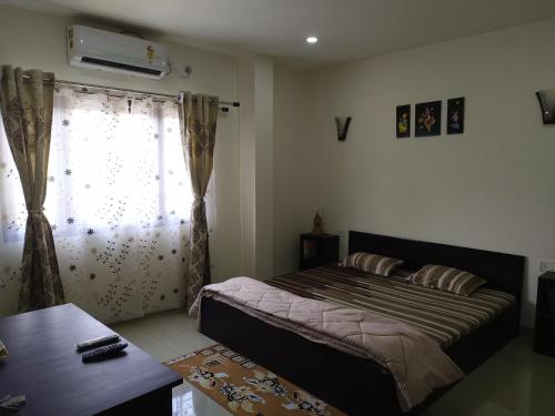 a bedroom with a large bed and a window at ALPANEST - Near GMCH and B Barooah Cancer in Guwahati