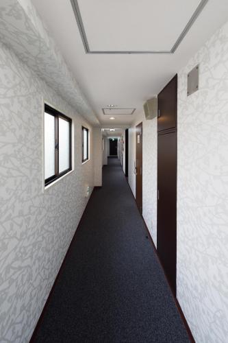 a corridor in an office building with a long hallway at Yokohama Sakuragicho Town Hotel in Yokohama