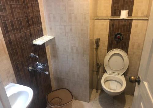 a small bathroom with a toilet and a sink at Ocean Inn Hotels in Bangalore