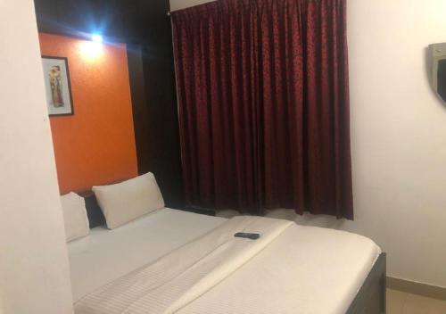 a bedroom with a bed and a red curtain at Ocean Inn Hotels in Bengaluru