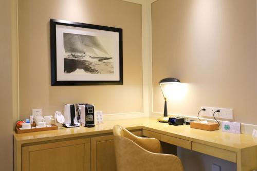 a desk with a lamp and chairs in a hotel room at Jinjiang Metropolo Hotel Classic Nanjing Road (East) Shanghai in Shanghai