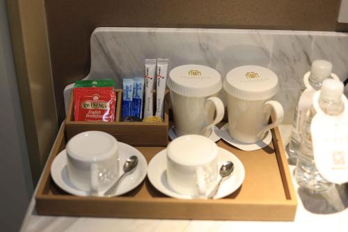 a tray with cups and saucers in a hotel room at Jinjiang Metropolo Hotel Classic Nanjing Road (East) Shanghai in Shanghai