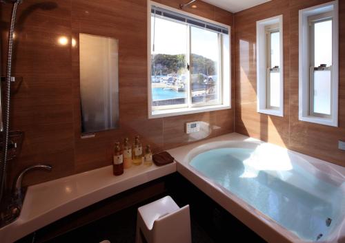 een grote badkamer met een bad en een raam bij Daikyo Engtsuto Villa in Shirahama
