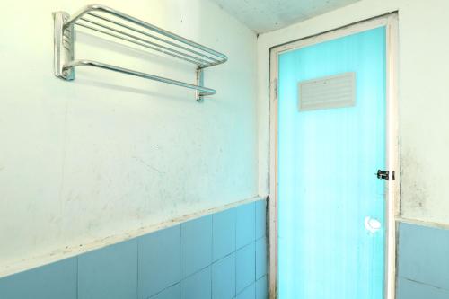 a bathroom with a blue door and a window at Homestay Mbah Parni in Sermo