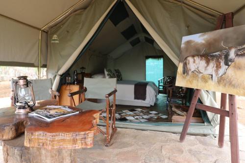 Sable Creek Safari Lodge في تزانين: لوحة سرير في خيمة