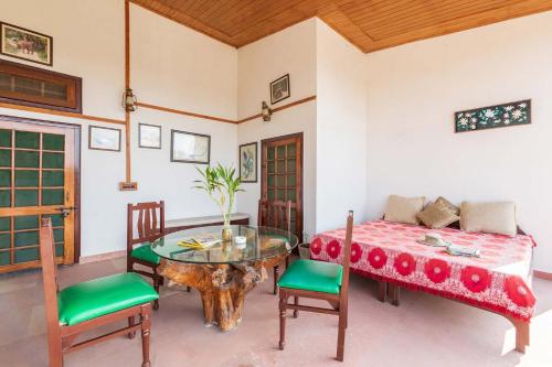 a dining room with a table and a bed at The Rangers Lodge, Imran's Jungle Home in Corbett in Rāmnagar