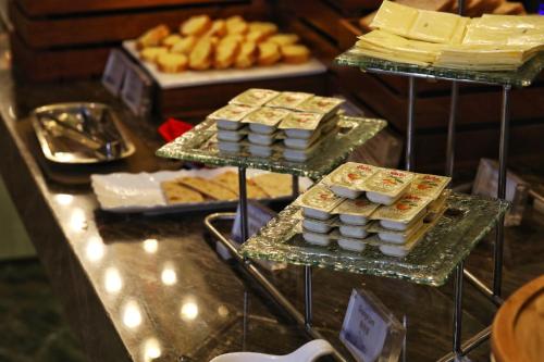 a buffet with several trays of cheese and other desserts at Jinjiang Metropolo Hotel Classic Nanjing Road (East) Shanghai in Shanghai