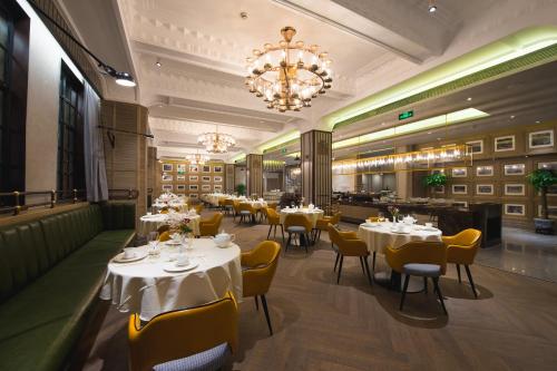 a restaurant with tables and chairs and a chandelier at Jinjiang Metropolo Hotel Classic Nanjing Road (East) Shanghai in Shanghai