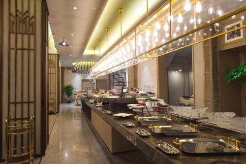 a restaurant with a buffet line with plates of food at Jinjiang Metropolo Hotel Classic Nanjing Road (East) Shanghai in Shanghai