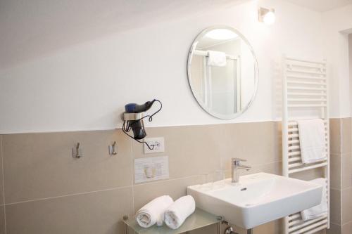 a bathroom with a sink and a mirror at Schenna Garni Eden Bed & Breakfast in Schenna