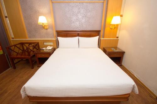 a bedroom with a large bed with two night stands at SL MOTEL in Zhonghe
