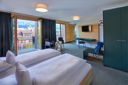 um quarto de hotel com duas camas e uma varanda em ElzLand Hotel 9 Linden em Elzach