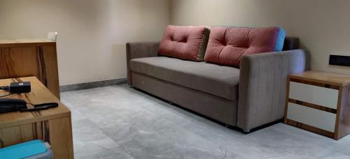 sala de estar con sofá y almohada rosa en Stay10 Studio Apartments en Indore