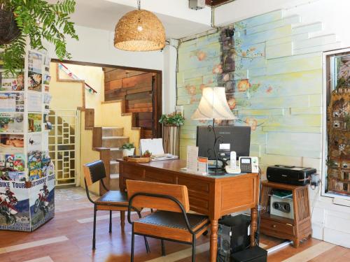 an office with a desk and chairs and a staircase at Changmoi House (Little Village) in Chiang Mai