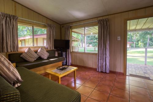 a living room with a couch and a table at Merry Pebbles Resort in Sabie
