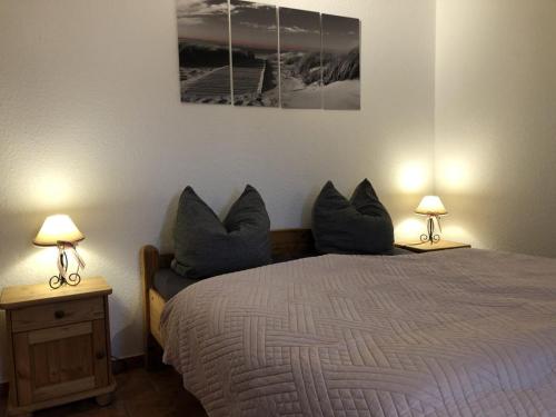 a bedroom with a bed with pillows and two lamps at Ferienwohnungen Camping SPO OHG in Böhl