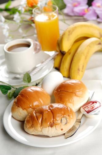 een bord met broodjes en bananen en een kop koffie bij New Gifu Hotel Plaza in Gifu