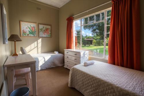 a bedroom with two beds and a window at Merry Pebbles Resort in Sabie