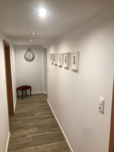 a hallway with a clock on a wall with pictures at Haus Marianne in Ettersburg