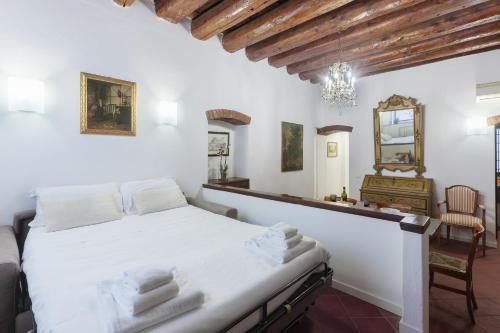 una camera con letto bianco e specchio di Center ZTL Lovely Apartment a Ferrara
