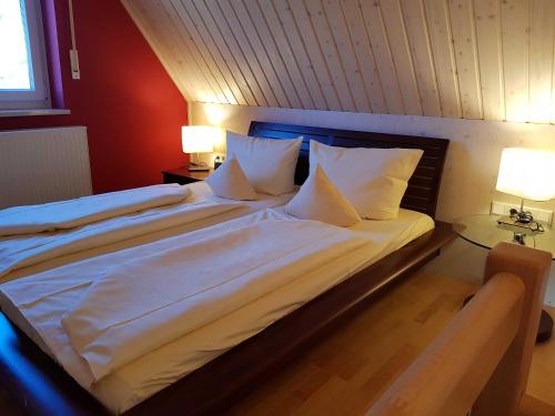 a bedroom with a large bed with white sheets and pillows at Ferienwohnungen Schlossblick in Muhr amSee