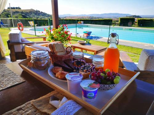 ein Tablett mit Frühstücksspeisen auf einem Tisch in der Nähe eines Pools in der Unterkunft Agriturismo Prati degli Orti in Montiano