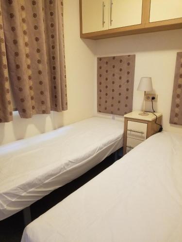 deux lits dans une chambre avec une lampe sur une table dans l'établissement MH 445 le bois dormant, à Saint-Jean-de-Monts