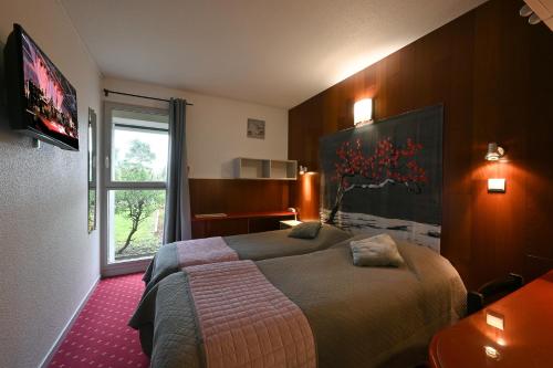 Un pat sau paturi într-o cameră la Logis Hotel Horus Restaurant Les Bruyeres
