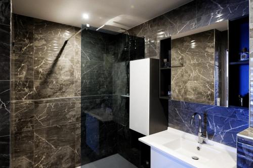 y baño con lavabo y ducha. en Le LUXE & votre VUE MER à Ouistreham Riva Bella, en Ouistreham