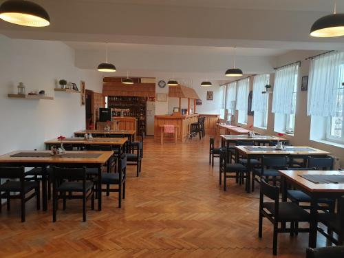 une salle à manger avec des tables et des chaises en bois dans l'établissement Penzion Kamzík, à Česká Kamenice