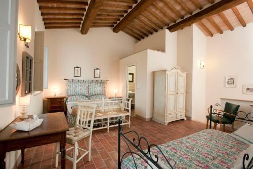 a bedroom with two beds and a table in a room at Villa Sant'Alberto in Monteroni dʼArbia