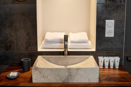 a bathroom with a sink with two towels at Maison Tillot in Dijon