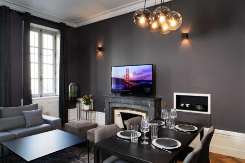 a living room with a table and a fireplace at Maison Tillot in Dijon