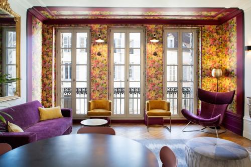 a living room with purple furniture and windows at Maison Tillot in Dijon