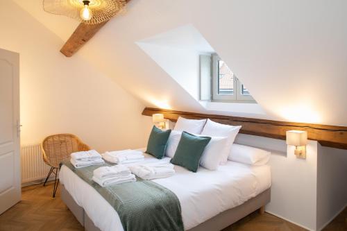 - une chambre avec un lit doté d'oreillers blancs et verts dans l'établissement Maison Tillot, à Dijon