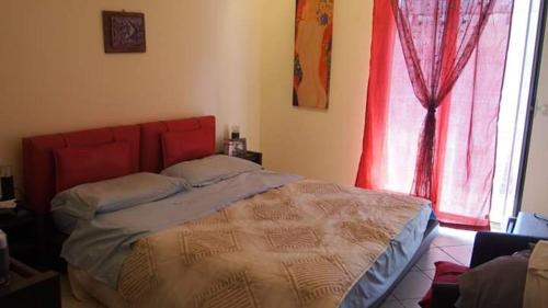 a bedroom with a bed with a red headboard and a window at Youth Hostel Medina in Meknès
