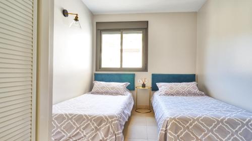 2 Einzelbetten in einem Zimmer mit Fenster in der Unterkunft Sea View Penthouse, Pool, Privacy, Benalmadena in Benalmádena