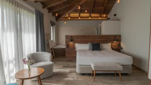 1 dormitorio con 1 cama, 1 silla y 1 mesa en Hotel Rural Cantexos, en Luarca
