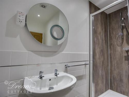 La salle de bains est pourvue d'un lavabo et d'un miroir. dans l'établissement Old Boathouse, à Weymouth