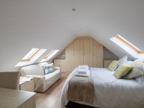 une chambre avec un lit, un canapé et des puits de lumière dans l'établissement The Lookout -The House With A View, à Weymouth