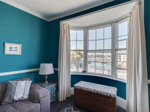 a living room with a couch and a large window at Sailor's Watch in Weymouth