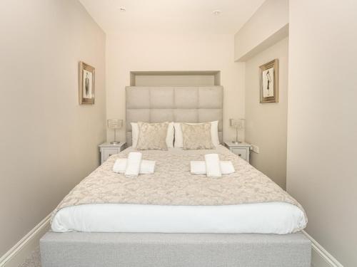 a bedroom with a large bed with two pillows at Harbour Watch 2 in Weymouth