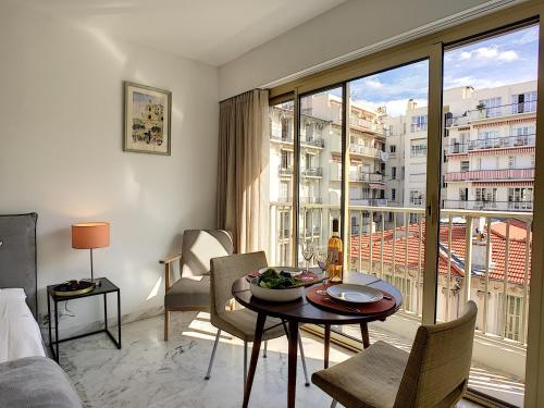 un salon avec une table et une grande fenêtre dans l'établissement Nestor&Jeeves - BERLIOZ SUITE - Downtown - Close beaches, à Nice