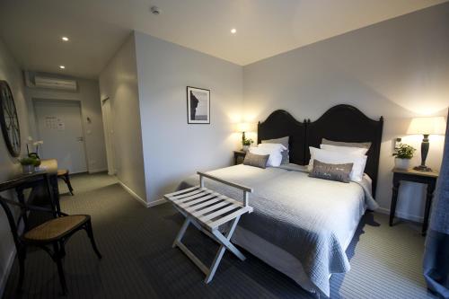 1 dormitorio con cama y banco. en Hotel et restaurant Le Clos De La Prairie, en Gouy-Saint-André