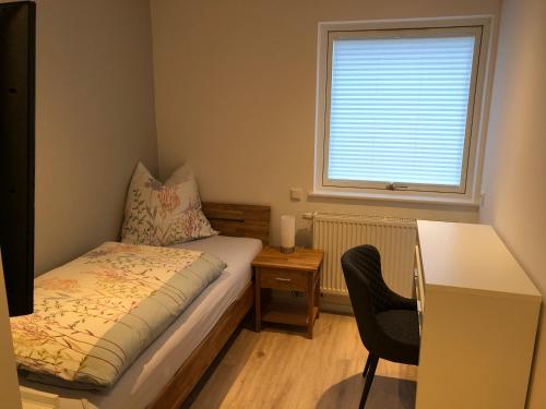 a bedroom with a bed and a desk and a window at Nordstern in Büdelsdorf