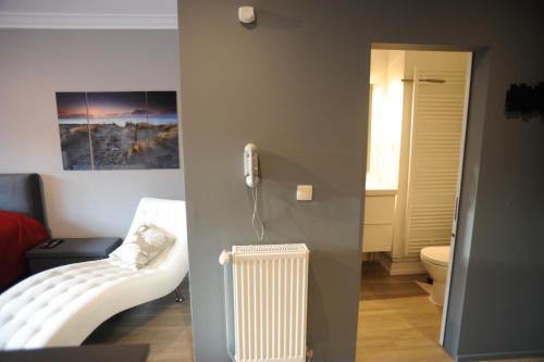 a room with a white radiator and a bathroom at Knokke Modern Studio in Knokke-Heist