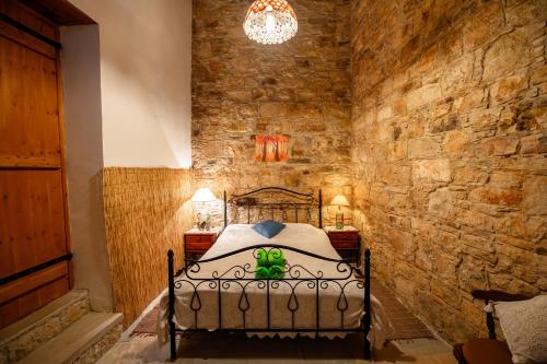 a bedroom with a bed in a stone wall at Constantias stone houses in Lofou